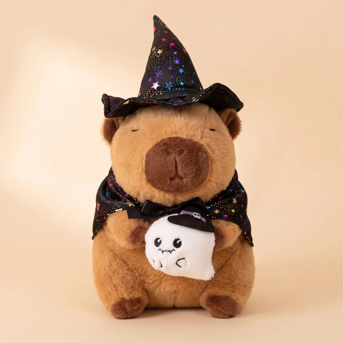 Front view of the ghost witch capybara plush holding a small white ghost