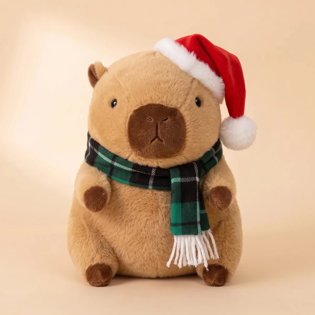 Front view of the Christmas capybara plush with a Santa hat and a green plaid scarf