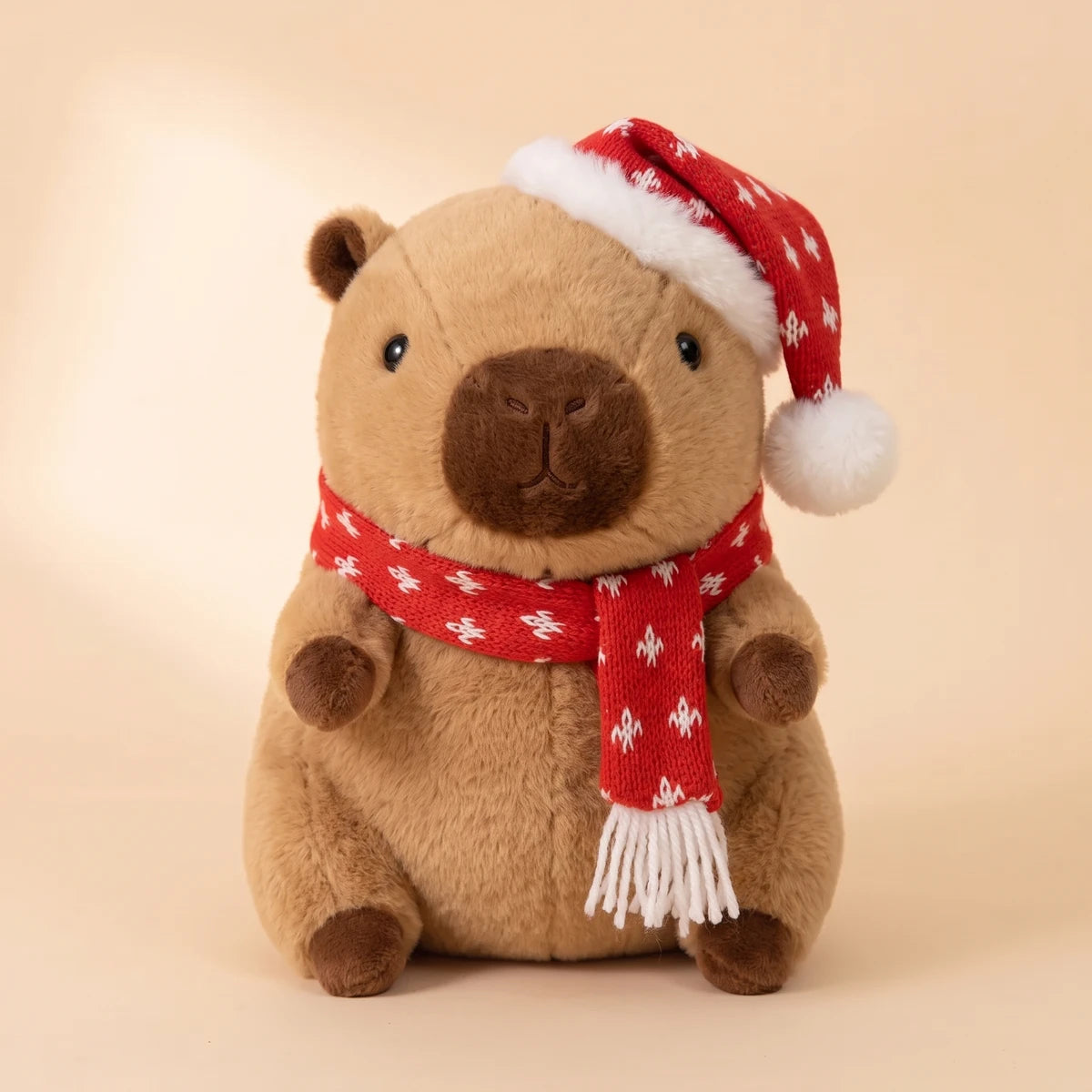 Front view of the Christmas capybara plush with a red knit hat and scarf dotted with snowflakes