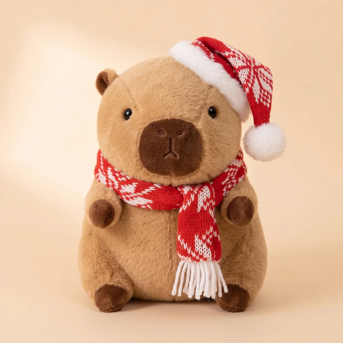 Front view of the Christmas capybara plush with a red snowflake knit hat and scarf