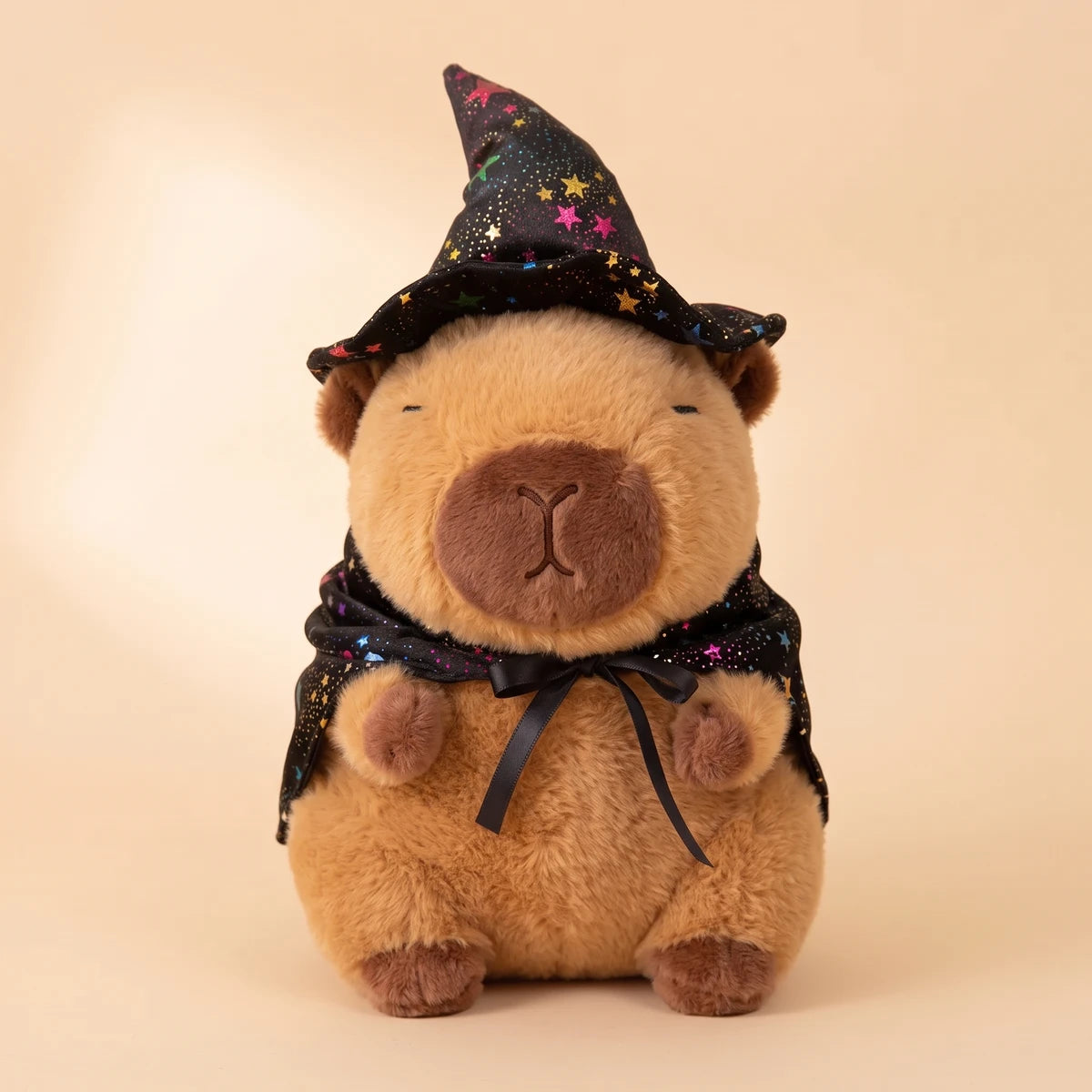 Front view of the witch capybara plush with a starry black hat and cape