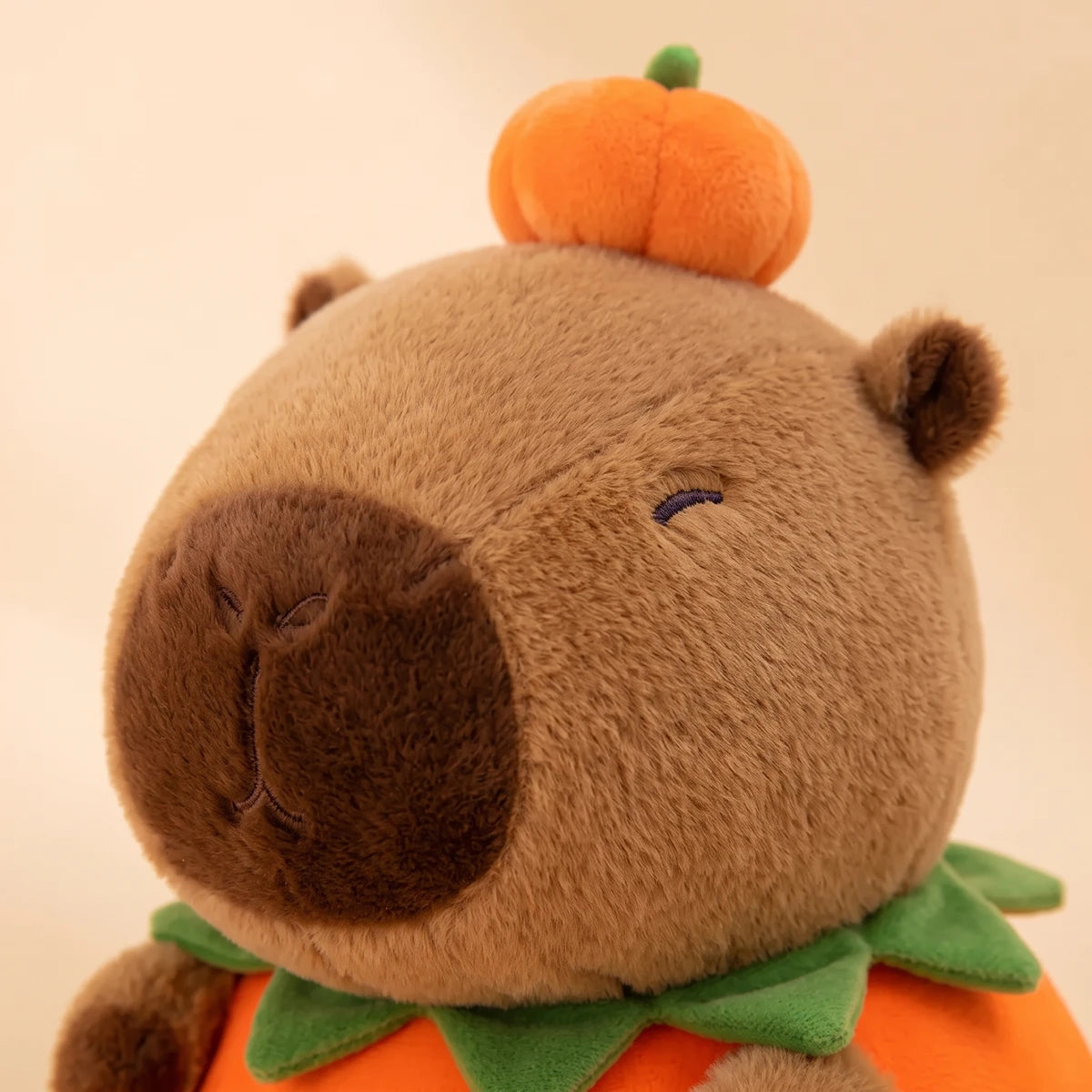 Close-up of the pumpkin capybara plush head with a small pumpkin on top
