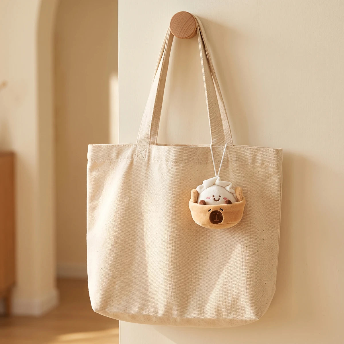 Dumpling capybara keychain hanging on a canvas tote bag