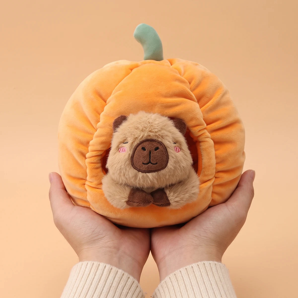 Pumpkin house capybara plush set held in two hands to show its 9 in size
