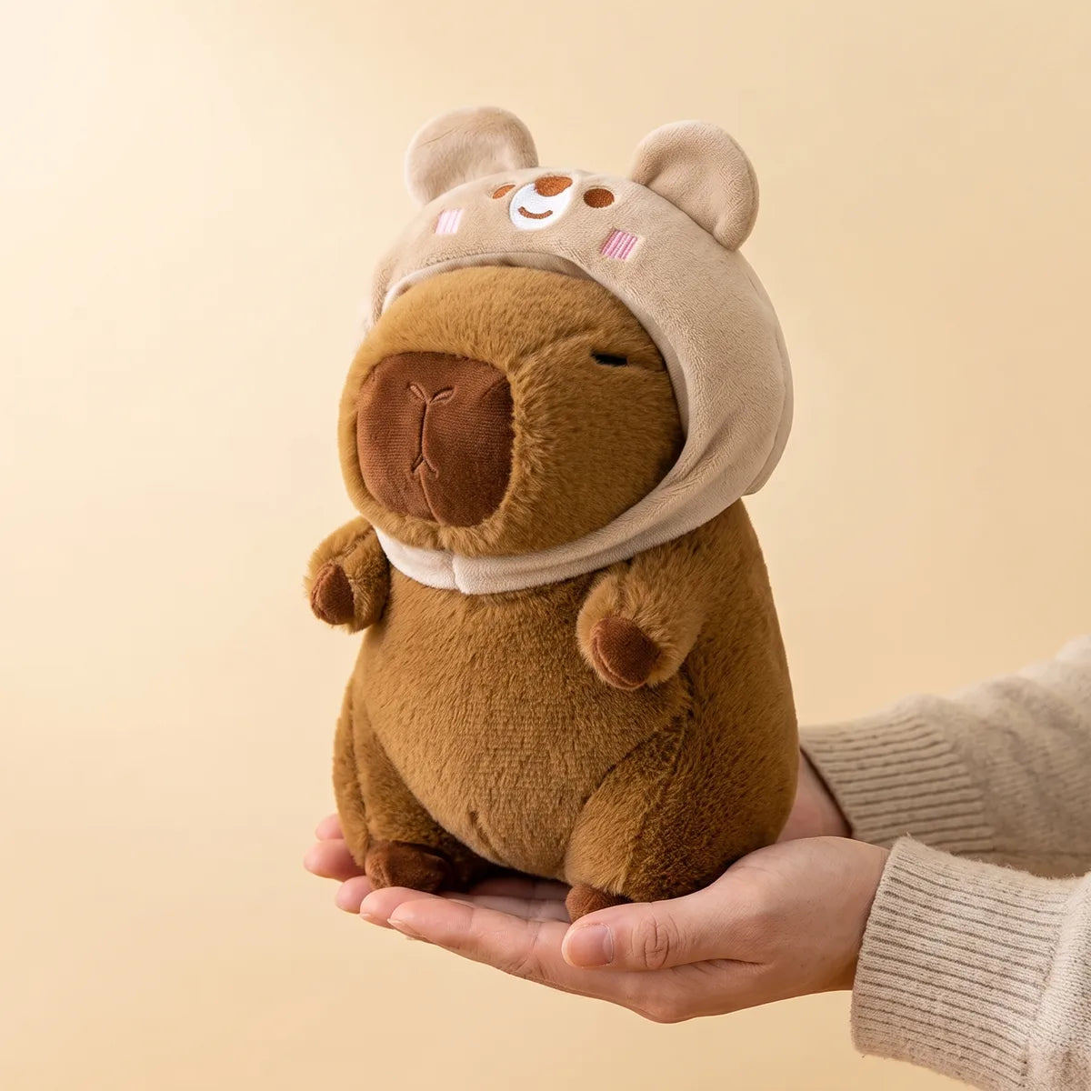 Hands cradling the 9 in (22 cm) bear capybara plush to show its real size
