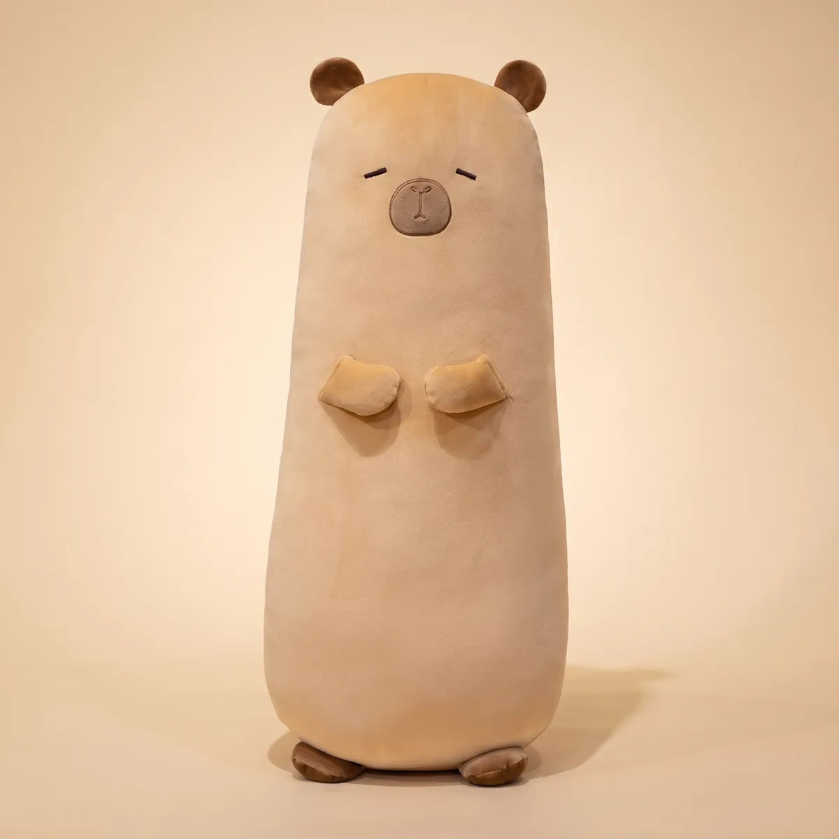 Big capybara stuffed animal plush photographed upright from the front on a cream studio background.