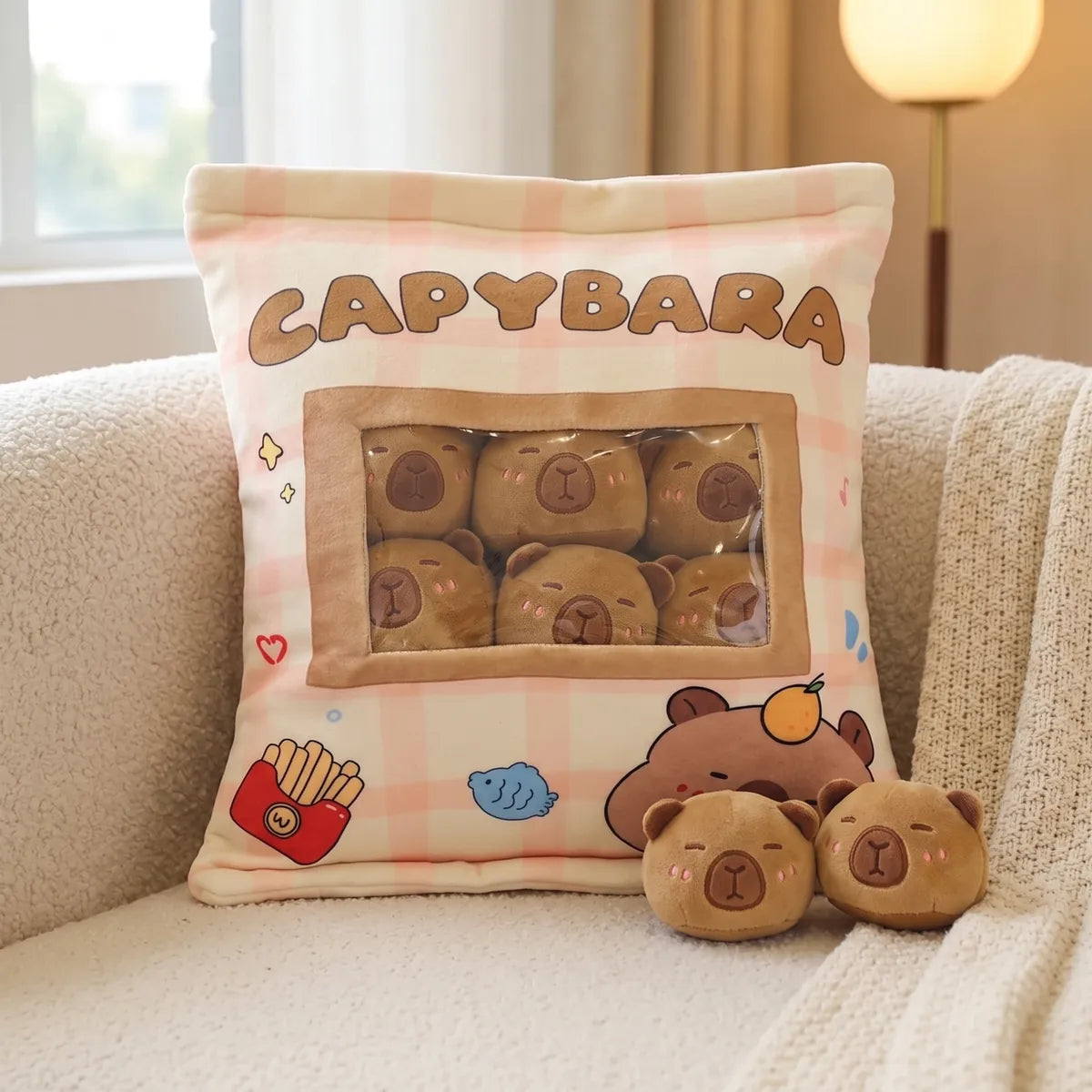 Brown mini capybara plush set on a cream boucle sofa with two tan minis sitting beside it