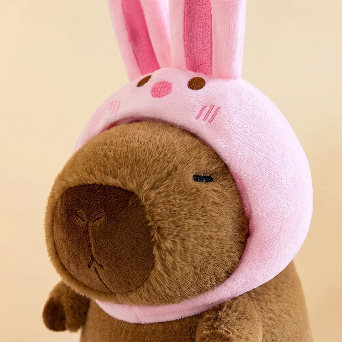 Close up of the tall pink ears and stitched rabbit nose on the capybara plush