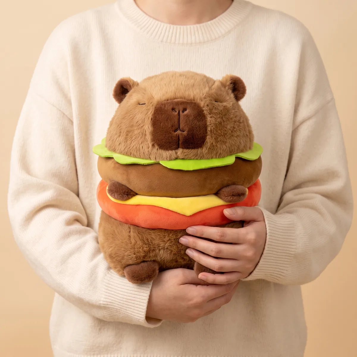 Person hugging the capybara burger plush against a sweater