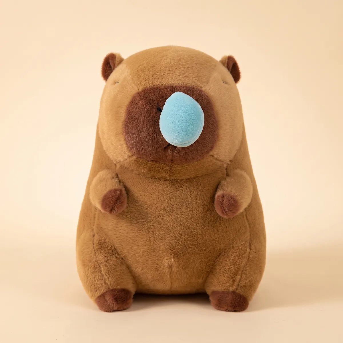 Front view of the brown capybara snot plush with a large pale blue bubble at one nostril and both eyes stitched shut