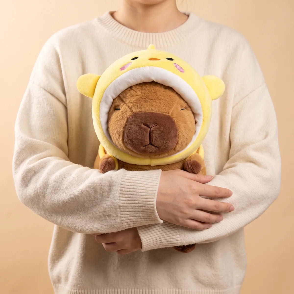 Person hugging the chicken capybara plush against a sweater