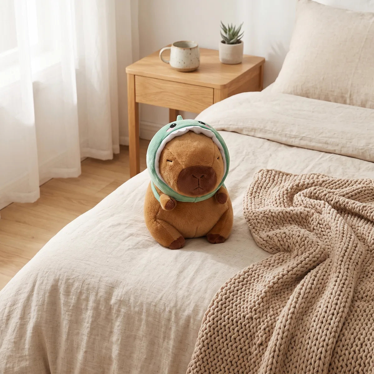 Dino capybara plush sitting on a linen bed