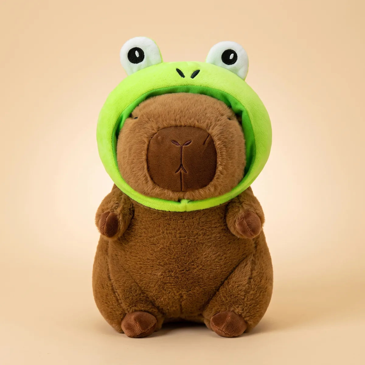 Brown frog capybara plush seen from the front in its lime green frog hood