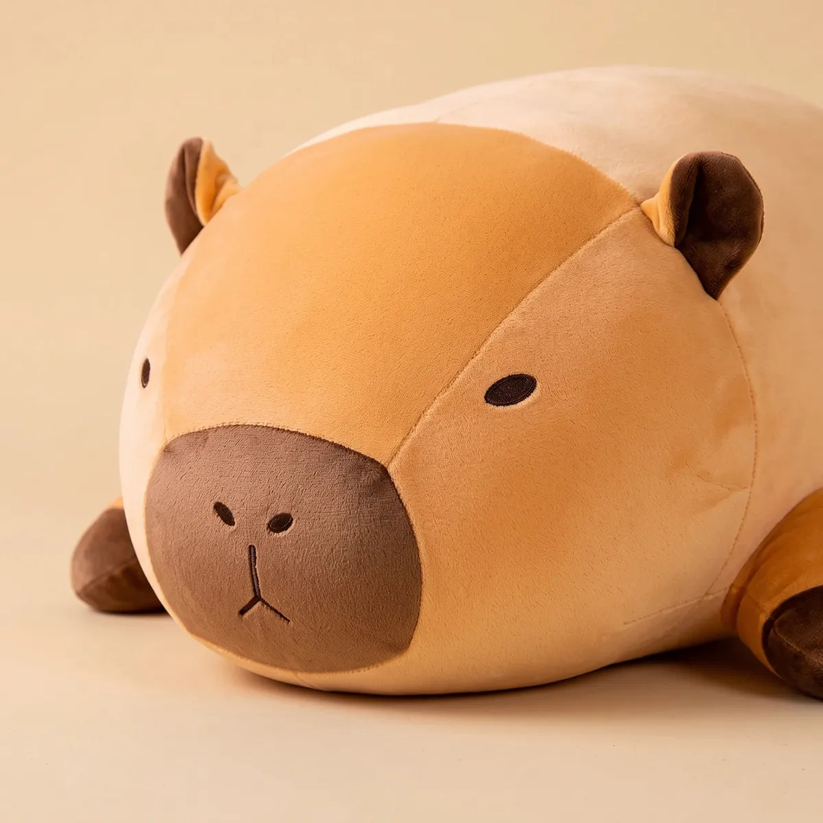 Close up of the dark muzzle and dot eye of the giant capybara plush
