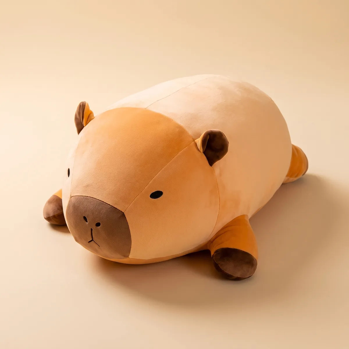 Giant capybara plush lying flat on the floor seen from the side