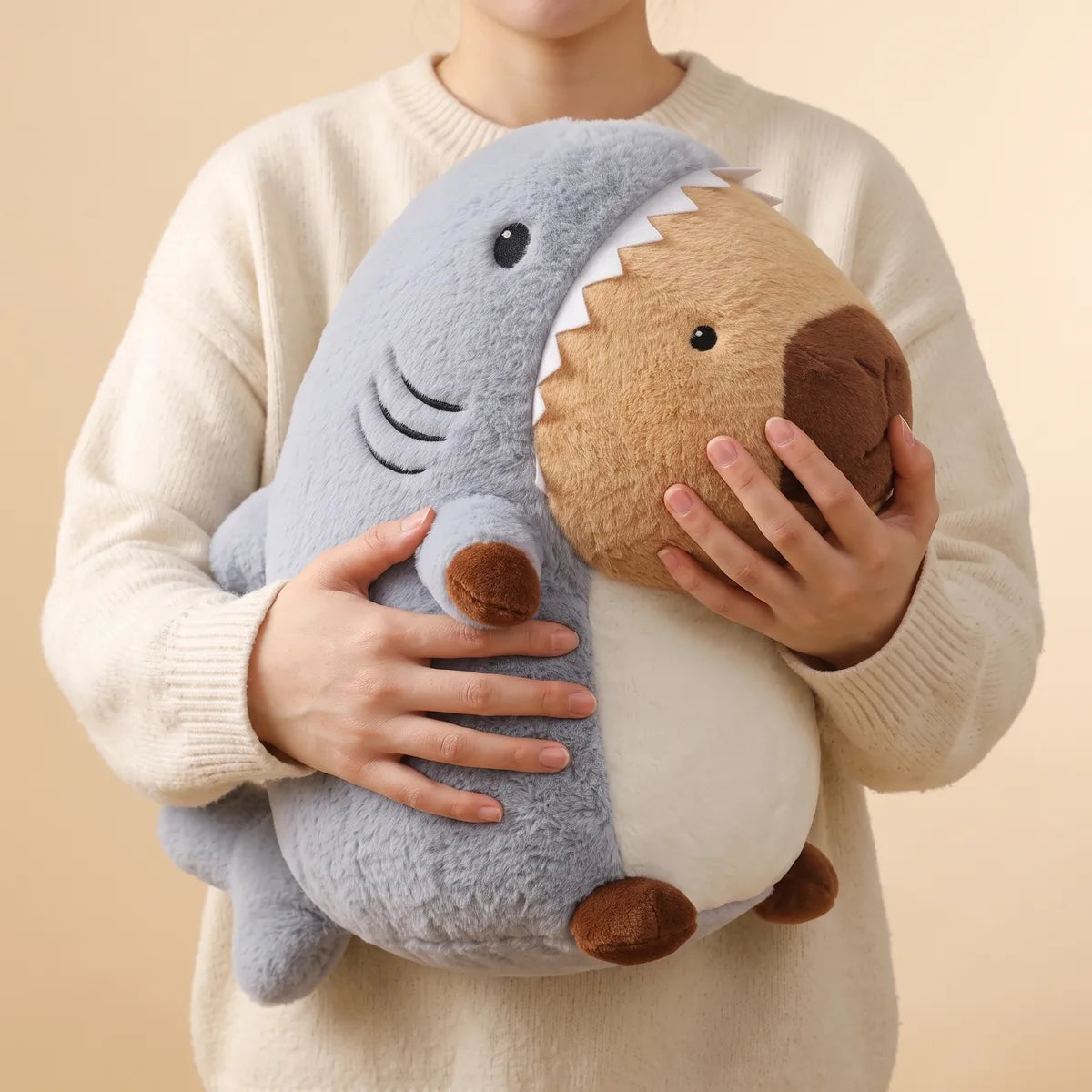 Person hugging the giant shark capybara plush with both arms