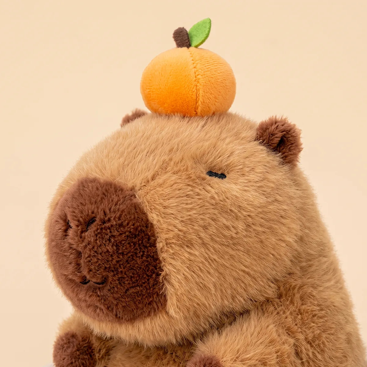 Close up of the capybara face and the fruit on its head above the mug rim