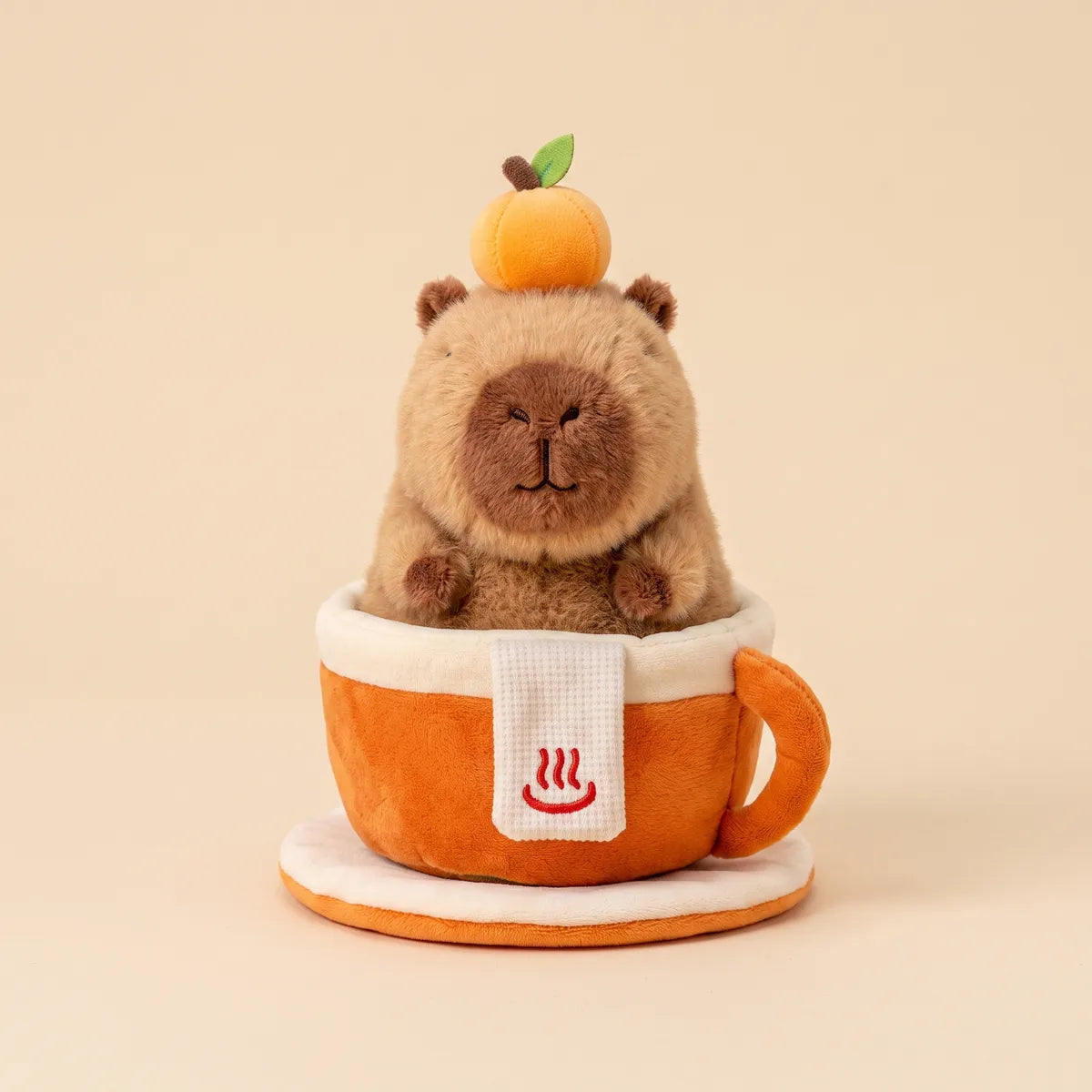 Capybara plush sitting inside its orange plush mug seen from the front