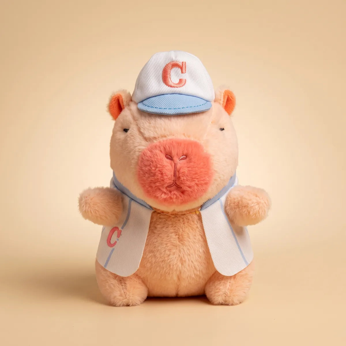 Front view of the 4 in pink baseball mini capybara plush in an open white jersey