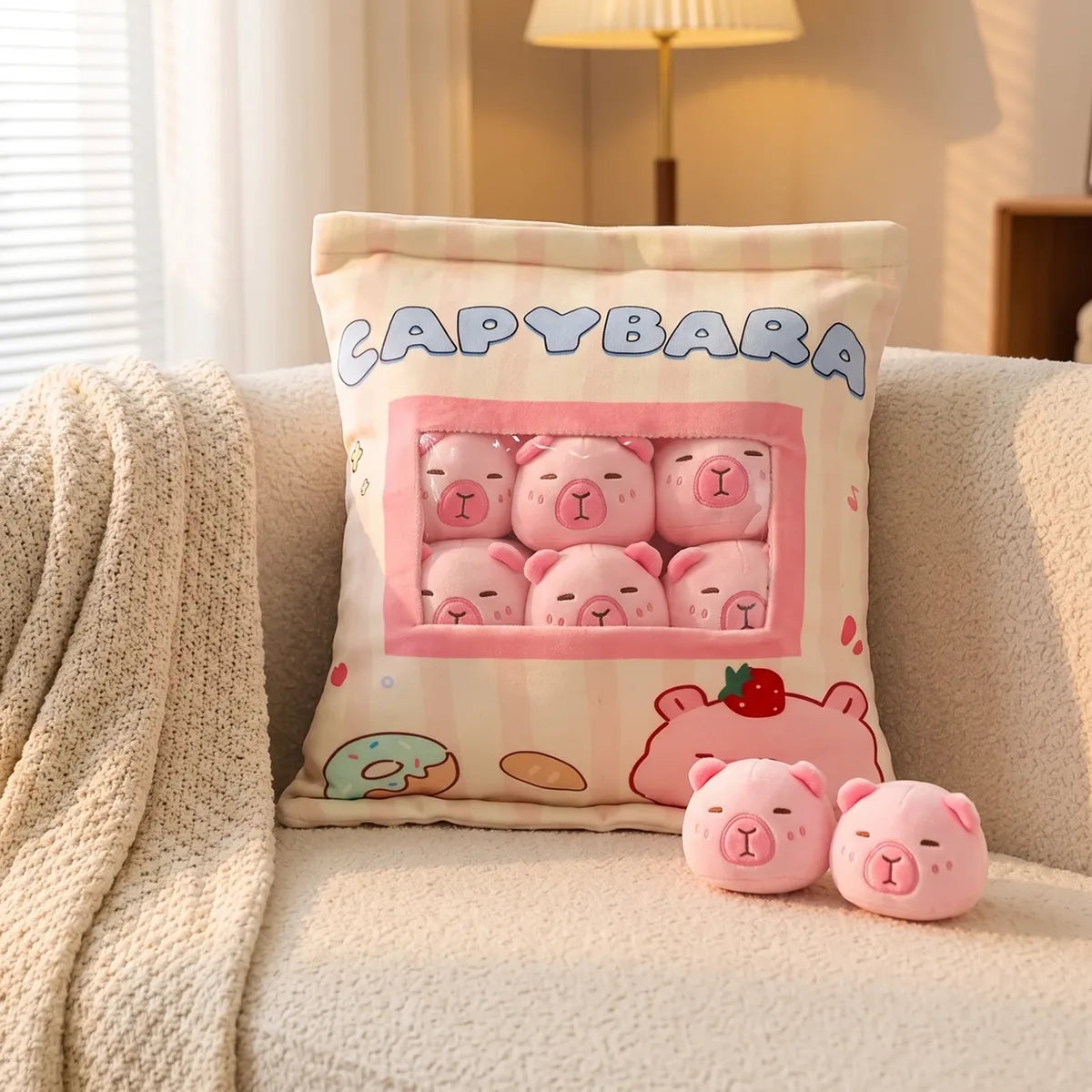 Pink mini capybara plush set propped on a boucle sofa with two pink minis sitting beside it