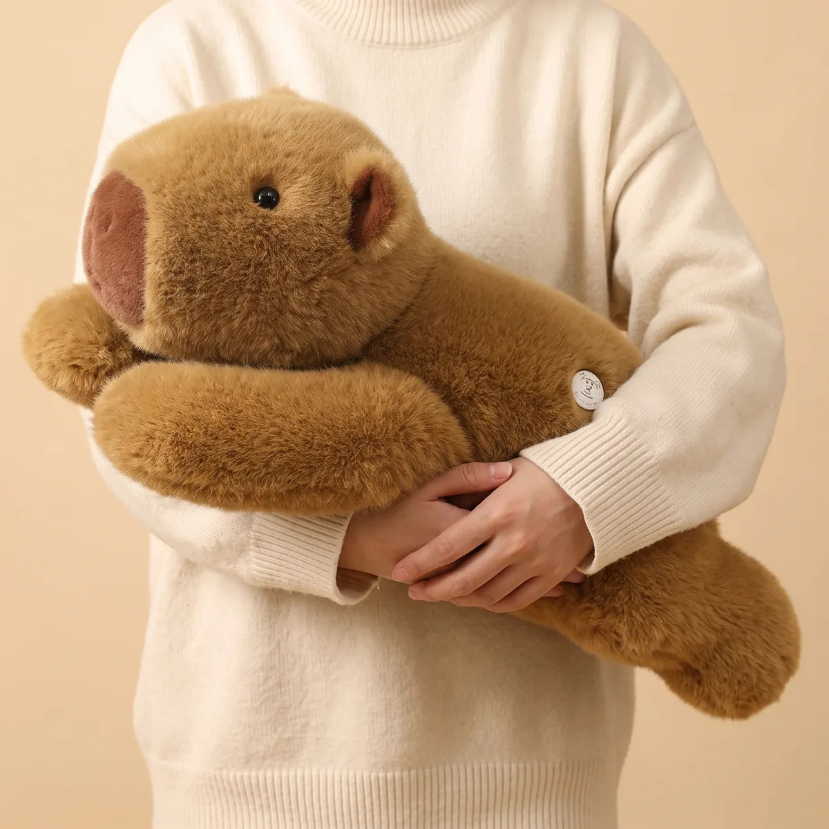 Person holding the 26 in weighted capybara plush to show its weight